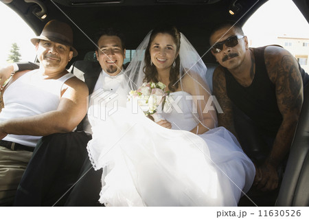 Hispanic newlyweds and family in limousine 11630526