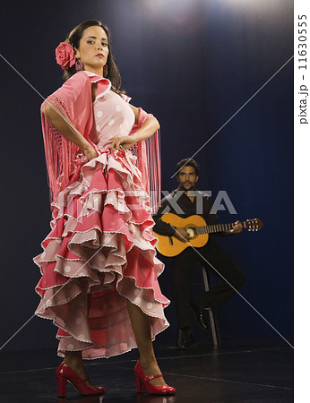 Hispanic female flamenco dancer with guitar player in background Hispanic female flamenco dancer with guitar player in background 11630555