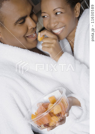 African woman feeding fruit to husband African woman feeding fruit to husband 11630589