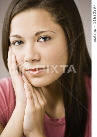 Asian girl resting chin on hands 11630597