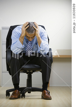 Middle Eastern businessman with head in hands Middle Eastern businessman with head in hands 11630609