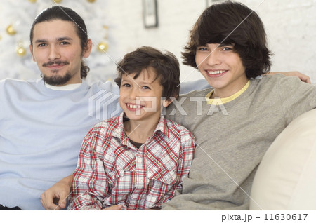 Hispanic brothers sitting on sofa 11630617