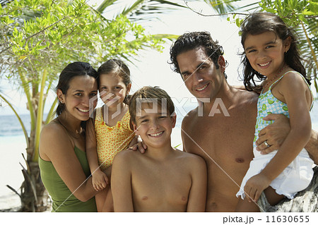 Hispanic family hugging at beach 11630655