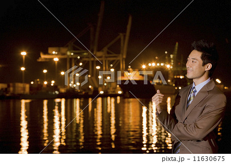 Asian businessman next to water at night 11630675