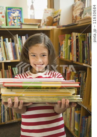 Pacific Islander girl holding library books 11630684