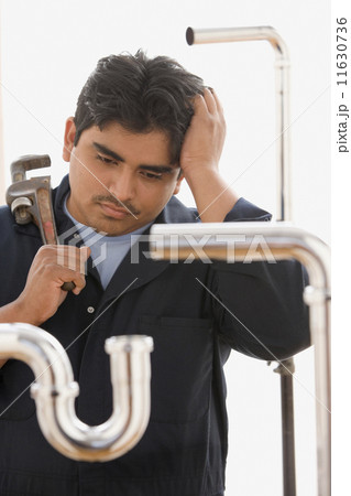 Confused plumber working on pipes Confused plumber working on pipes 11630736