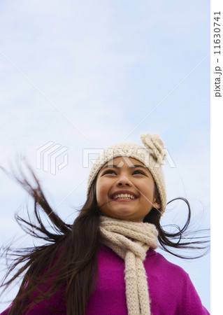 Young Hispanic girl wearing hat and scarf outdoors 11630741