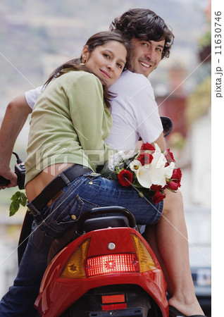 Hispanic couple on scooter 11630746