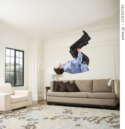 Hispanic businessman doing flip in livingroom 11630793