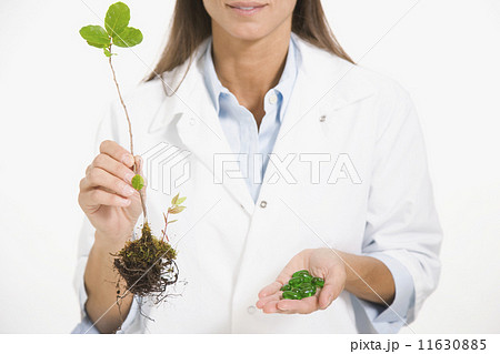Maltese female scientist holding plant and medication Maltese female scientist holding plant and medication 11630885