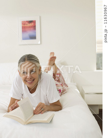 Asian woman reading on bed 11630967