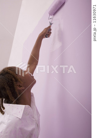 African American woman painting with roller 11630971