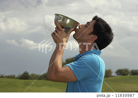 Hispanic man kissing golf trophy 11630987