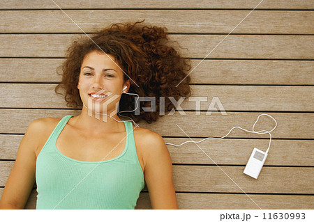 Young woman listening to mp3 player 11630993