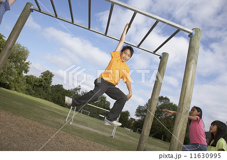 Asian boy hanging on jungle gym 11630995