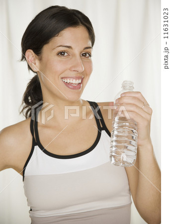 Hispanic woman holding bottled water 11631023