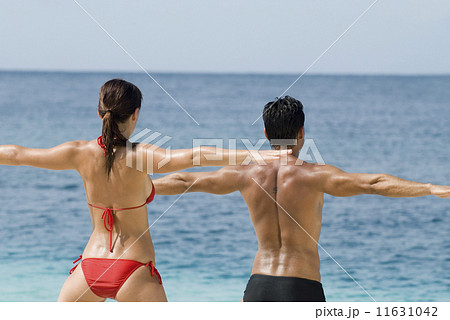 Multi-ethnic couple practicing yoga at beach Multi-ethnic couple practicing yoga at beach 11631042