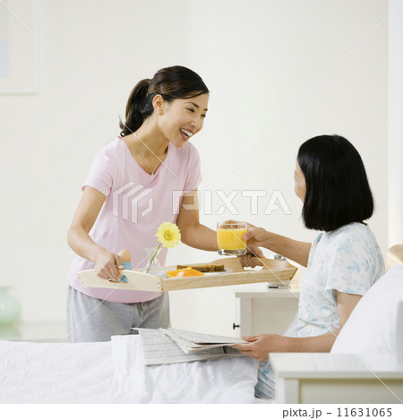 Asian woman bringing mother breakfast in bed Asian woman bringing mother breakfast in bed 11631065