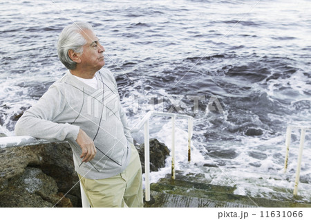 Man standing on stairs by the sea Man standing on stairs by the sea 11631066