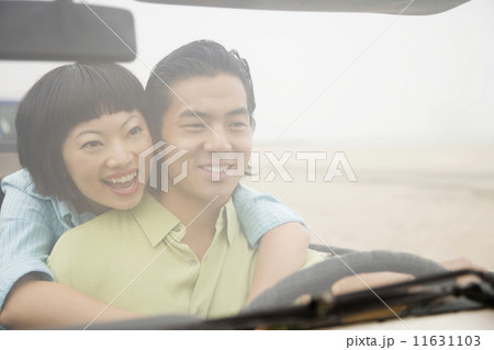 Asian couple hugging in convertible 11631103