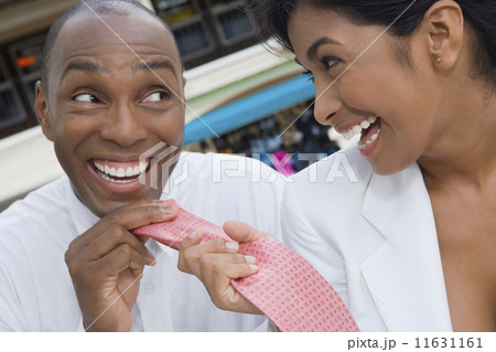 Hispanic woman pulling boyfriend's necktie 11631161