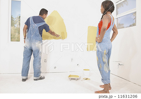 Rear view of couple painting walls 11631206