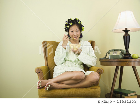 Asian woman in curlers eating cereal 11631255