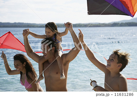 Hispanic family flying kites at beach Hispanic family flying kites at beach 11631286