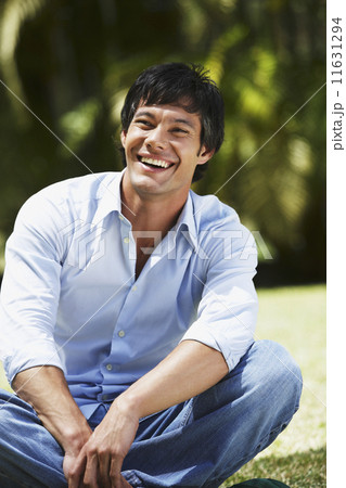 South American man sitting in grass 11631294