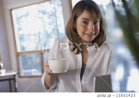 Hispanic woman holding coffee mug 11631423