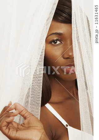 African woman looking through curtains African woman looking through curtains 11631465
