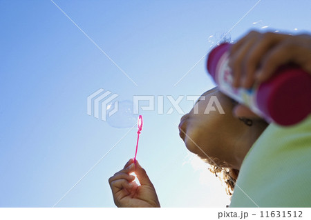 Low angle view of girl blowing bubbles Low angle view of girl blowing bubbles 11631512