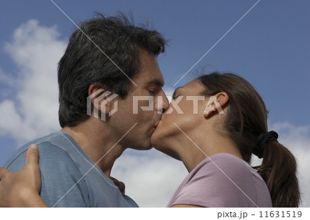 Low angle view of Hispanic couple kissing 11631519