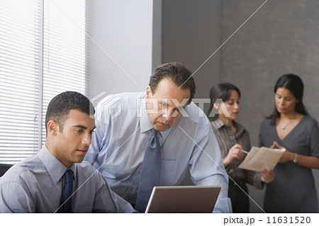 Hispanic businessmen looking at laptop 11631520