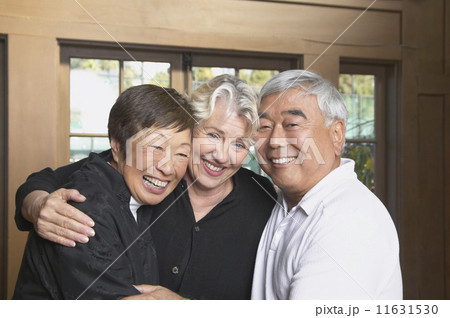 Three senior friends hugging and smiling 11631530
