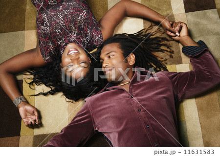 African American couple laying on floor holding hands 11631583