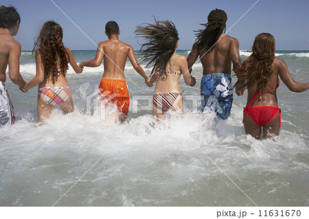 Rear view of multi-ethnic friends in ocean 11631670