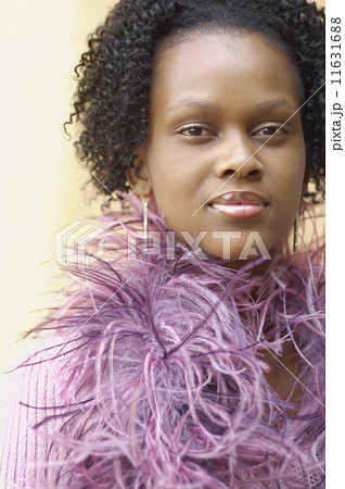 Close up of young African woman with feather boa 11631688