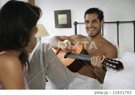 Hispanic man playing guitar for girlfriend 11631702