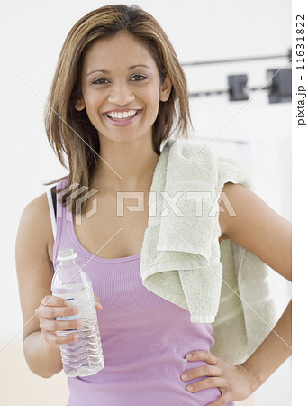 Indian woman holding water bottle and towel 11631822