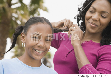 African mother braiding daughter's hair African mother braiding daughter's hair 11631832