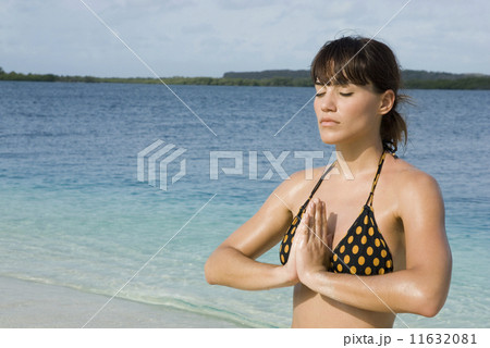 Hispanic woman practicing yoga at beach Hispanic woman practicing yoga at beach 11632081