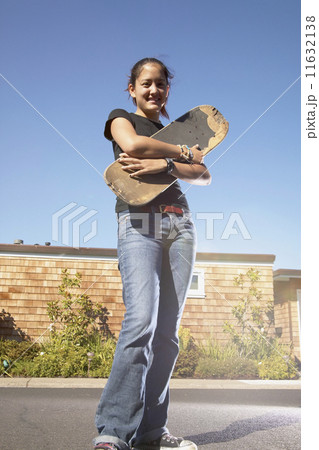 Teenage girl holding skateboard Teenage girl holding skateboard 11632138