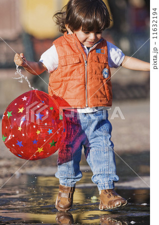 Hispanic boy walking in puddle 11632194