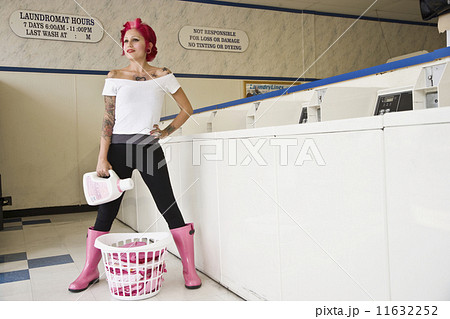 Tattooed Hispanic woman in laundromat Tattooed Hispanic woman in laundromat 11632252