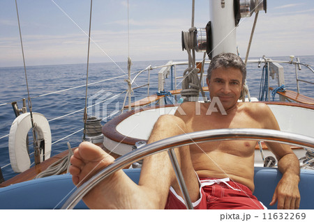 Man steering sailboat with foot 11632269