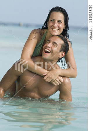 Hispanic couple playing in water 11632356