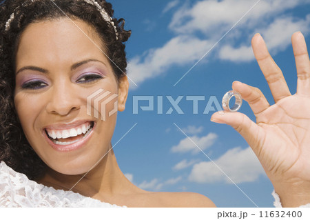 Hispanic bride holding ring 11632400
