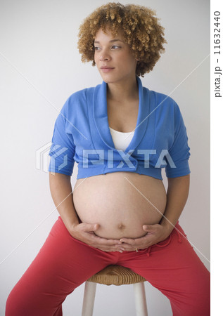 Pregnant African woman with hands on belly 11632440