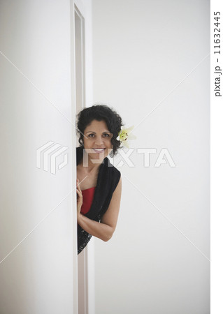 Woman leaning out of doorway smiling 11632445